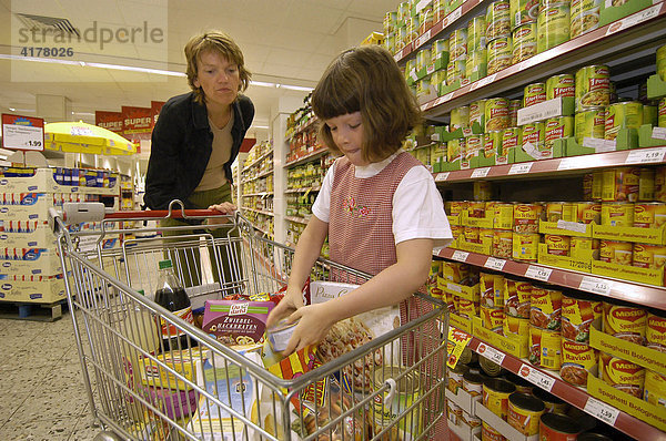 Mutter mit Kind beim Einkaufen in einem Supermarkt.