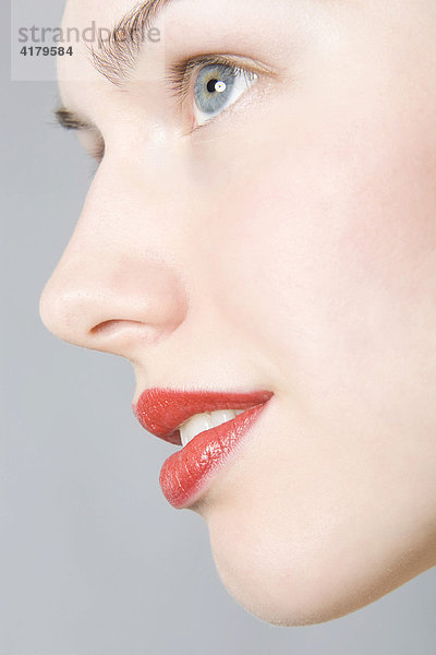 Nahaufnahme des Gesichts einer jungen Frau mit roten Lippen im Profil mund