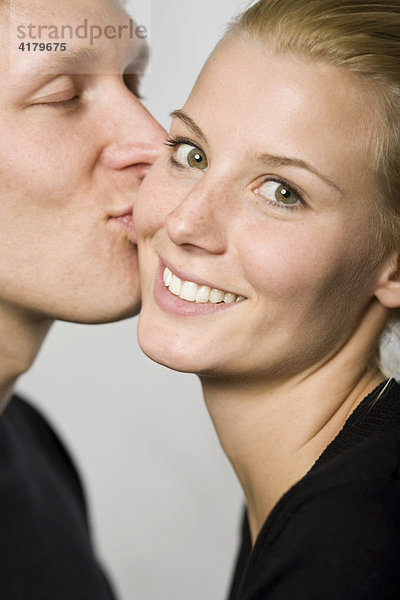 Mann küsst Frau auf die Wange