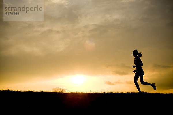 Silhouette einer Läuferin vor Sonnenuntergang