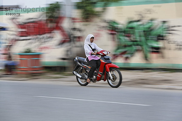 Mädchen auf Motorrad in Tenggarong  Ost-Kalimantan  Borneo  Indonesien