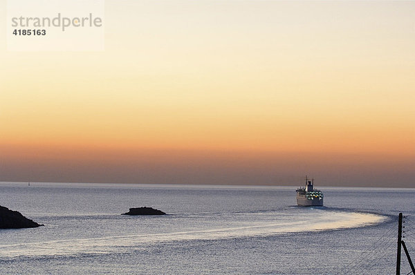 Eine Fähre verlässt den Anleger von Kythnos bei Sonnenuntergang am Abend  Kykladen  Griechenland.