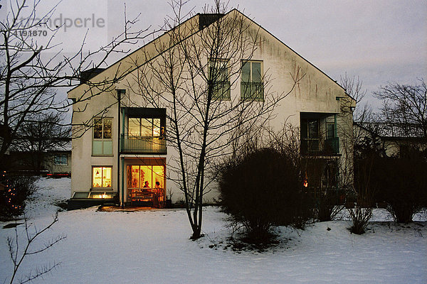 Haus im Winter mit erleuchtetem Fenster