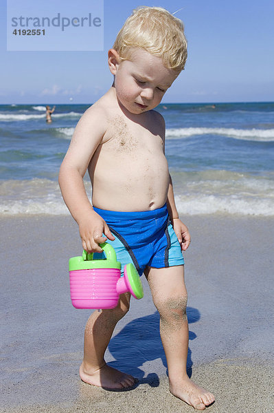 Ein kleiner Junge spielt am Strand von Can Picafort  Mallorca
