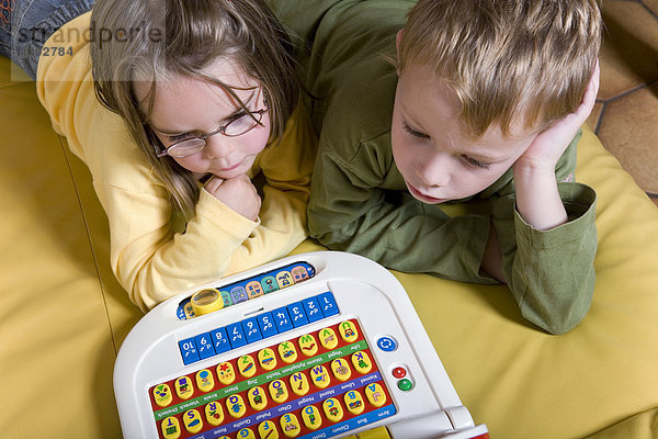 Zwei Vierjährige spielen mit einem Kinder-Computer