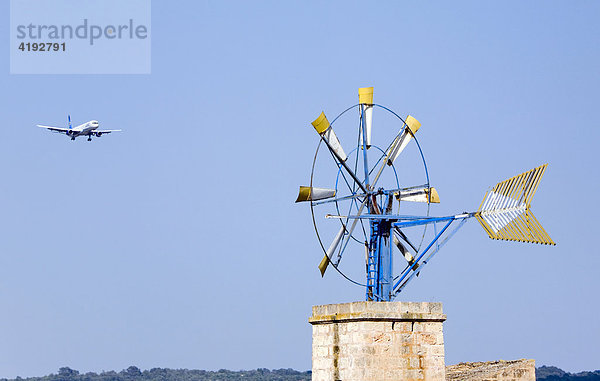 Ein Flugzeug der Gesellschaft Condor im Anflug auf den Flughafen Palma de Mallorca  im Vordergrund eine der typischen Windmühlen  Mallorca  Balearen  Spanien