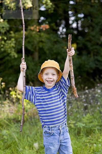 Ein Junge  vier Jahre alt  sammelt im Wald Stöcke