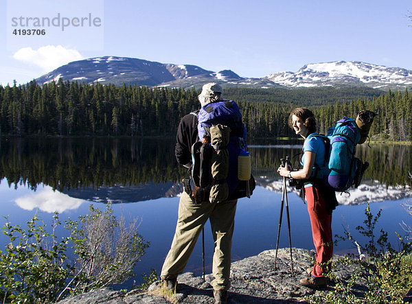 Wanderer genießen den Ausblick auf den spiegelglatten Dan Johnson Lake  Chilkoot Trail  Britisch Columbien  Kanada