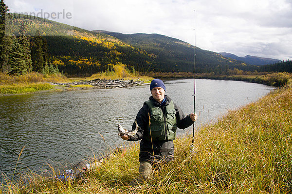 Angler mit Fang am Ufer des Big Salmon River  Fluss  Wasser  Yukon Territorium  Canada