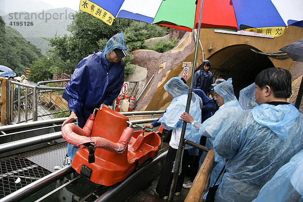 Chinesische Touristen auf dem Weg zur Chinesischen Mauer mit der Bahn  Regen  Peking  Beijing  China