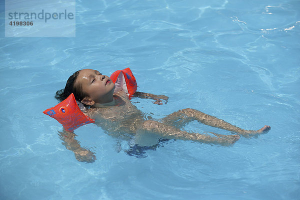 Junge mit Schwimmflügeln im Pool