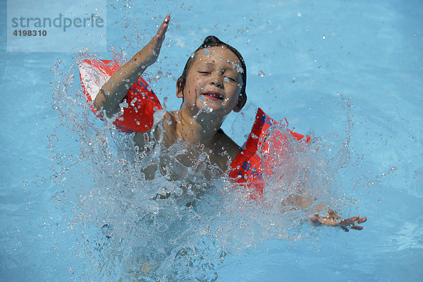 Junge mit Schwimmflügeln im Pool