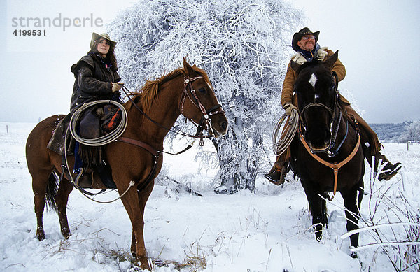 Cowgirl und Cowboy überblicken auf Pferden  Kanada