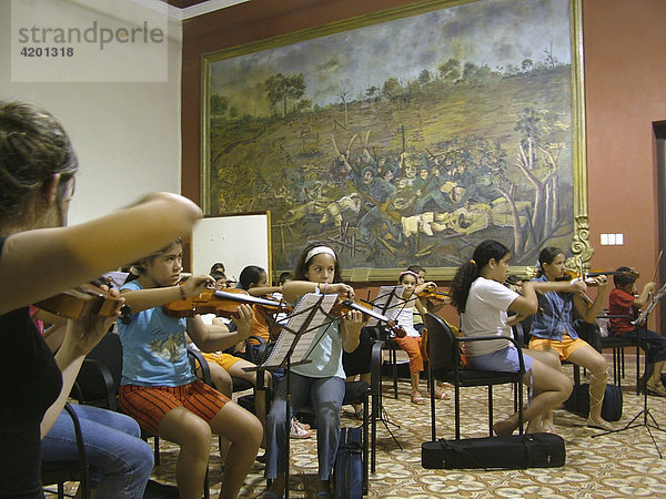 Paraguayische Kinder beim Geigenspiel vor überdimensionalem Gemälde  Concepcion  Paraguay