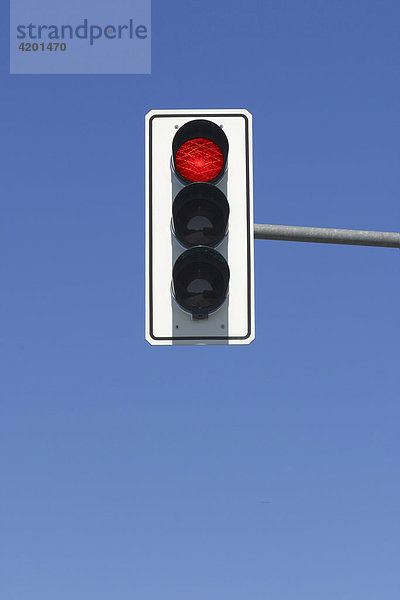 Red traffic light in blue sky