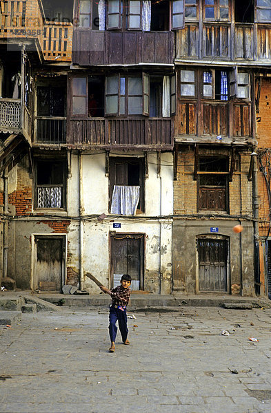 Kricket spielender Junge in einem Innenhof in Kathmandu  Nepal  Asien