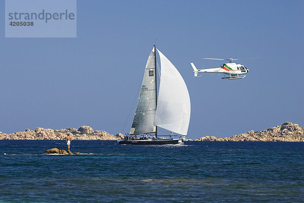 Segelboot mit Hubschrauberbegleitung an der Costa Smeralda  Sardinien Italien