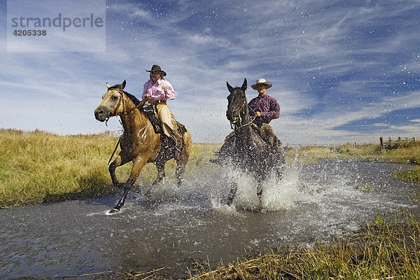 Cowboy und Cowgirl reiten in Bachbett Wilder Westen Oregon USA
