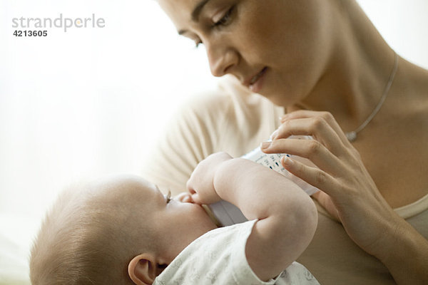 Mutter füttert Kleinkind mit Babyflasche