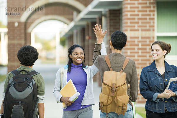 Klassenkameraden geben sich gegenseitig High-Five.