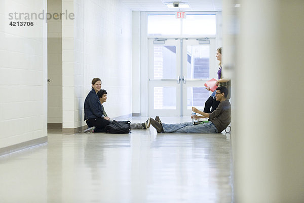 Highschool-Freunde  die zusammen im Schulflur rumhängen.