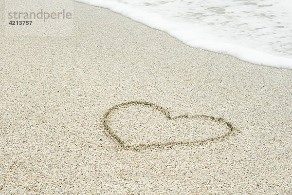 Im Sand gezeichnetes Herz am Strand