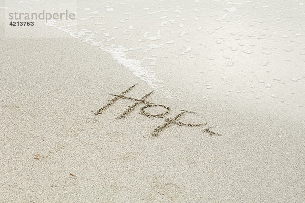 Das Wort Hoffnung   geschrieben im Sand am Strand  teilweise von der Flut weggespült .