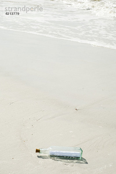 Nachricht in einer Flasche am Strand angespült