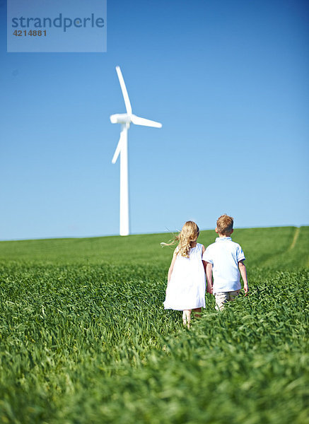 Junge und Mädchen schauen auf Windkraftanlage