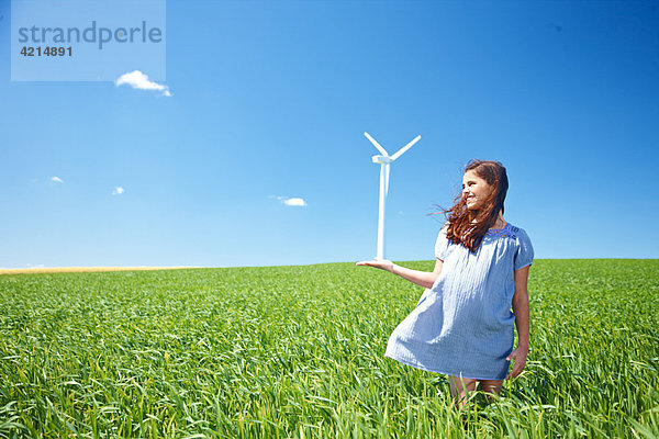 Mädchen auf dem Feld mit Windkraftanlage