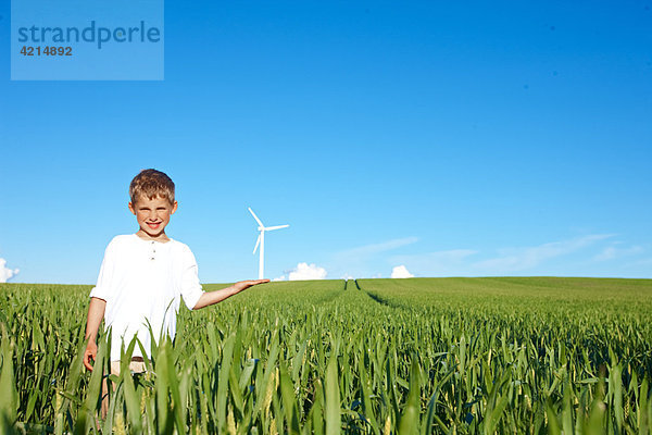 Junge auf dem Feld mit Windkraftanlage