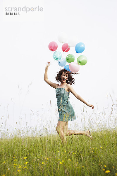 Frau mit Luftballonspringen