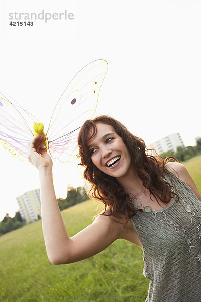 Frau hält Spielzeug Schmetterling aus der Nähe