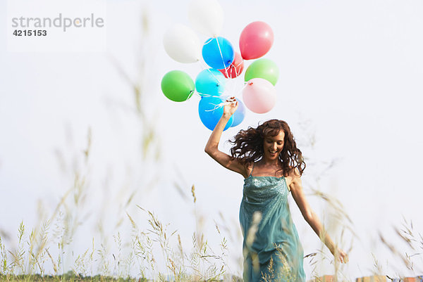 Frau mit Luftballons beim Gehen