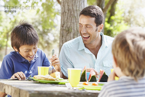 Glücklicher Vater mit 2 Jungen beim Picknick