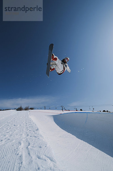 Snowboardfahrer In der Luft schwebend springen