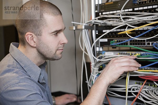 Mann kümmert sich um Netzwerkkabel