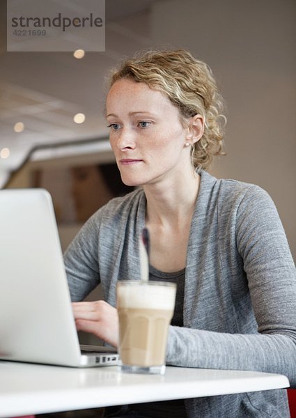 Frau mit Laptop im Kaffeehaus