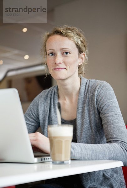 Frau mit Kaffee und Laptop