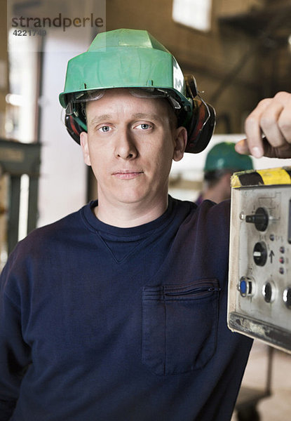 Mann mit grünem Helm bei der Arbeit