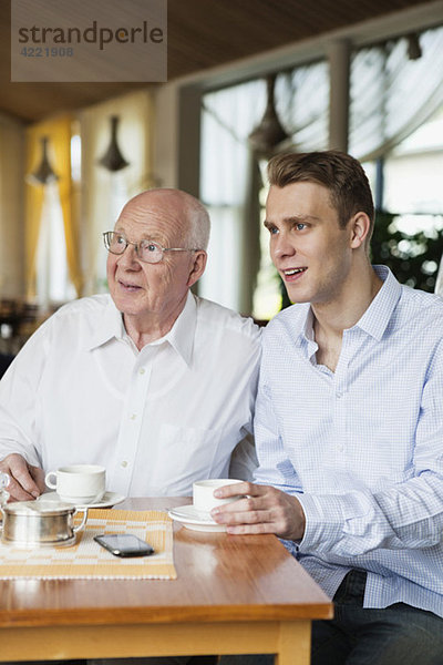 Alter Mann und junger Mann beim Kaffeetrinken