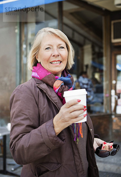 Frau mit Kaffee zum Mitnehmen im Freien