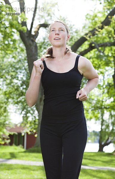 Frau in schwarz läuft im Park