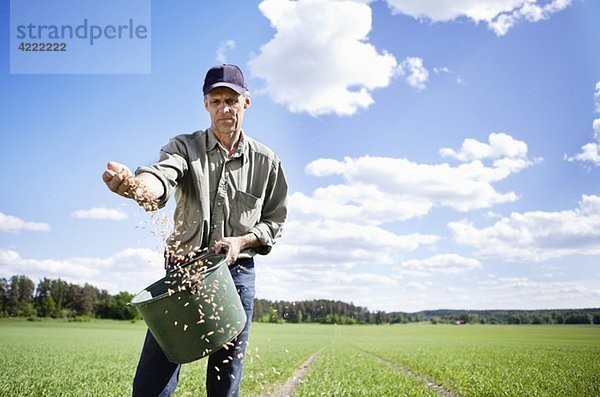 Landwirt beim Ausbringen von Saatgut