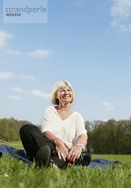 Frau auf Gras sitzend