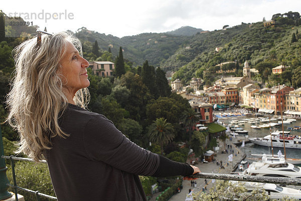 Seniorin schaut auf Hafen und Häuser  Italien  Portofino