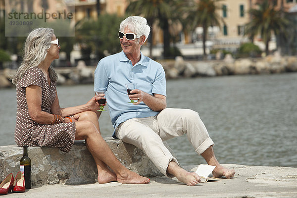 Seniorenpaar trinkt Rotwein am Wasser  Italien  Rapallo