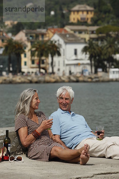 Seniorenpaar trinkt Rotwein am Wasser  Italien  Rapallo