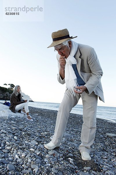 Senior schaut auf Steine am Strand  Italien  Sori
