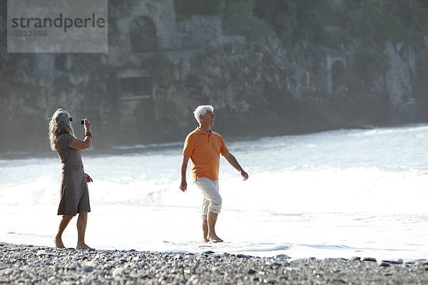 Seniorenpaar geht am Strand spazieren  Italien  Sori